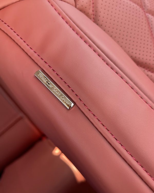 Bhola Car Seat Cover metal badge stitched into a red leather bolster beside perforated diamond quilting