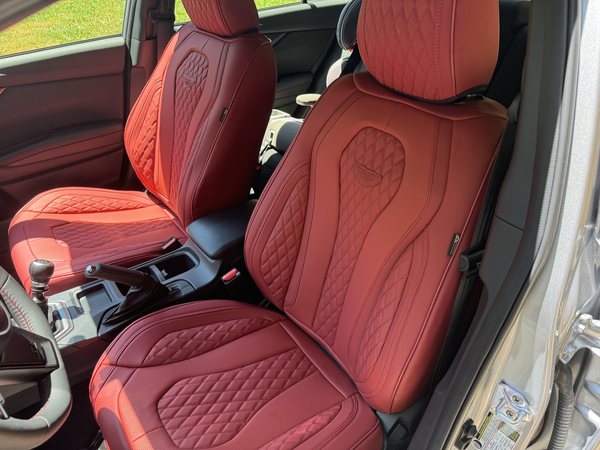 Red leather seat covers with diamond quilting, perforated inserts and an embossed headrest motif